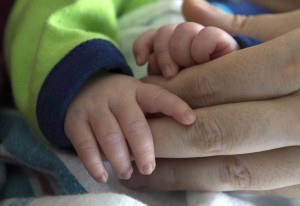 Little Stefan Mijatovic holds his mother Vera’s hand in the Neonatal Intensive Care Unit (NICU) at Spectrum Health Helen DeVos Children’s Hospital Friday, May 8, 2015.